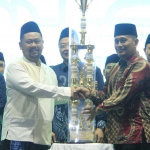 Bupati Fandi Akhmad Yani (kiri) menerima piala bergilir MTQ dari Camat Bungah Moh. Izzul Muttaqin. foto: ist.
