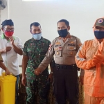 Camat Blimbing Muarib, Ketua RW 23, serta jajaran Forpimka Blimbing tampak mengenakan masker dan APD, Selasa (24/03). foto: ist.