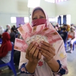 Siti Marsiyah, salah satu KPM menunjukkan uang BLT. Foto: Ist.