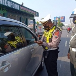 Petugas saat melakukan pengecekan terhadap salah satu mobil di Pos Penyekatan P1 Waru, Sidoarjo.