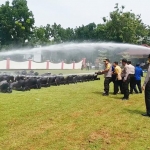 Kapolres Bangkalan AKBP Rama S. Putra menyiram 69 personel yang mendapatkan anugerah kenaikan pangkat.