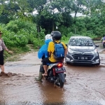 Akibat hujan deras, jalan Raya Tlekung-Oro-oro Ombo banjir. Tampak petugas Satsabhara Polres Batu mengatur arus lalu lintas.