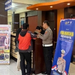 Petugas saat menyosialisasikan Polantas Menyapa kepada warga yang datang ke Kantor Samsat Kota Kediri. Foto: Ist