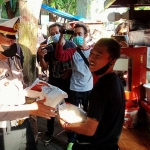 Petugas kepolisian saat membagikan sembako pada PKL di Alun-Alun Kota Probolinggo.