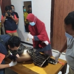 Petugas saat memeriksa jenazah seorang nenek dari Dusun Patilaler, Desa Deyeng, Kecamatan Ringinrejo Kabupaten Kediri, yang tewas tenggelam usai menceburkan diri ke sumur. Foto: Ist