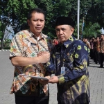 Sekda Gresik Andhy Hendro Wijaya menyerahkan SK kenaikan pangkat kepada perwakilan PNS. foto: SYUHUD/ BANGSAONLINE