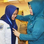 Ketua TP PKK Gresik Hj. Maria Ulfa Sambari saat mengalungkan id card peserta pelatihan. foto: SYUHUD/ BANGSAONLINE