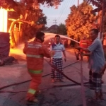 Petugas pemadam kebakaran saat memadamkan kobaran api pada gudang kayu di Dusun Bunut, RT02/RW06, Desa Randegansari, Kecamatan Driyorejo, Gresik. Foto: Ist