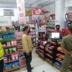 Petugas gabungan saat memberi imbauan tetap jaga jarak dan pakai masker di sebuah toko swalayan. (foto: MUJI/ BANGSAONLINE)