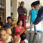 Agus Mulyanto selaku Kepala Desa sekaligus Ketua Tim Gugus Tugas Penanganan Covid-19 Desa Karang Pao saat membagikan masker kain kepada warga setempat.