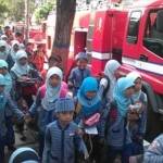 PANIK. Ratusan siswa-siswi berhamburan keluar gedung SD Muhammadiyah, Bojonegoro. Siswa ketakutan karena gardu induk listrik di ruang guru terbakar. Foto: Eky Nurhadi/BANGSAONLINE
