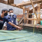 Erwin Wahyu Nugroho dan Kepala Disperdagin Jatim, Drajat Irawan, saat melihat proses pembuatan tenun ikat di Kampung Tenun Ikat, Bandar Kidul, Kota Kediri. Foto: Ist