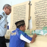 Ahmad Yani didampingi Kalapas Rudi Sarjono saat menulis ayat-ayat Al Quran . foto: AKINA/ BANGSAONLINE