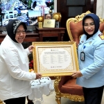 Wali Kota Risma saat menerima penghargaan khusus dari Kepala Kantor Wilayah Kemenkumham Jawa Timur Susy Susilawati. foto: ist