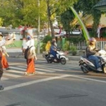 Petugas Dishub dan Polres Mojokerto Kota sedang membantu menyeberangkan para pelajar.