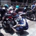 DAPAT BANYAK: Petugas dari Dishub saat menggembosi ban motor yang parkir sembarangan. foto: devi/ BANGSAONLINE