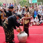 Bupati Nganjuk, Marhaen Djumadi saat mengambil air yang dibawakan gadis dari air terjun Sedudo. Foto: Bambang Dwi Julianto/BANGSAONLINE