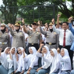 Kapolres Batu AKBP Harviadhi Agung Prathama bersama jajaran foto bersama para siswa usai upacara di SMA Negeri 2 Batu.