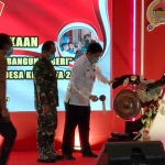 Sekda Kabupaten Kediri Dede Sujana saat memukul gong sebagai tanda dibukanya TMMD ke-112 Kodim 0809/Kediri. foto: MUJI HARJITA/ BANGSAONLINE