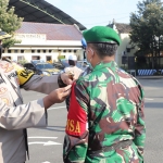 Kapolres Kediri AKBP Lukman Cahyono saat menyematkan tanda kepada anggota TNI yang akan terlibat dalam Operasi Semeru 2021. (foto: ist)