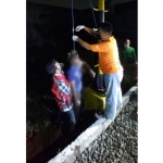 Petugas saat mengevakuasi korban bunuh diri di tiang signal kereta api antara stasiun Tandes dan Kandangan.
