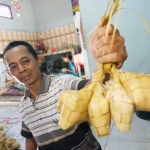Ahsan menunjukkan ketupat bikinannya yang telah matang. foto: RONY S/ BANGSAONLINE