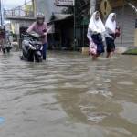 NEKAT: Warga menerobos air banjir yang merendam kawasan Kelurahan Sidokare Kecamatan Kota Sidoarjo, Senin (10/10) siang. foto: MUSTAIN/ BANGSAONLINE