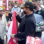 Wali Kota Madiun Maidi membagikan bendera Merah Putih dan susu  kepada warga yang melintas di depan Balai Kota Madiun.
