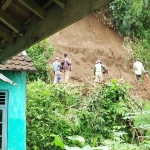 Warga dibantu petugas Kepolisian kerja bakti membersihkan sisa material longsor.