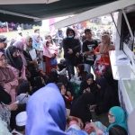 Warga antre mengurus adminduk melalui Mobil Monalisa Dispendukcapil Jember yang parkir di Lapangan Yosorati saat program Bunga Desaku.