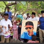 Sandiaga Uno memegang lukisan Gombloh mengenakan topi dengan angka 2 yang diprotes keluarga dan fans Gombloh. foto: ist