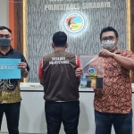 Tersangka saat diapit petugas Satresnarkoba Polrestabes Surabaya beserta barang bukti yang diamankan.