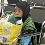 Mbah Satinah saat tiba di bandara King Abdulaziz Jeddah sambil memangku oleh-oleh sajadah yang ia beli untuk keluarga di rumah. Foto: Sulthon/MCH 2026.