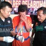 Tersangka Arif bersama petugas Polres Tanjung Perak. foto: ekoyono/ BANGSAONLINE