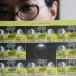 Pegawai menunjukkan perangko edisi Gerhana Matahari Total di Kantor Pos Pasar Baru, Jakarta, Selasa (23/2).  foto: merdeka.com