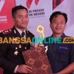 Kapolres Sampang, AKBP Siswantoro, saat menyerahkan penghargaan pada jurnalis pemenang lomba artikel feature. Foto: MUTAMMIM/BANGSAONLINE