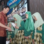 Kapolrestabes Surabaya Kombespol Sandi Nugroho saat memberikan santunan kepada anak-anak yatim piatu.