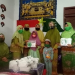 Ketua PAC Muslimat NU Kecamatan Pesantren Kota Kediri, Siti Asiyah dan jajaran pengurus saat membagikan masker dan bantuan kepada anak yatim. (foto: ist).