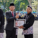 Bupati Lamongan Yuhronur Efendi saat menyerahkan penghargaan kepada Kurniawan Adi Prasetyo, Pencetus Bank Benih Solokuro.