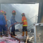 Petugas usai menjinakkan api yang melalap toko cat dan tiner di Sidoarjo.