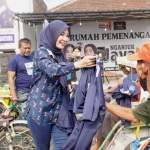 Calon Bupati Nganjuk Ita Triwibawati saat membagikan kaos kepada abang becak sebelum berangkat blusukan.