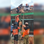 Relawan saat memperbaiki rumah warga yang rusak usai diterjang angin puting beliung.