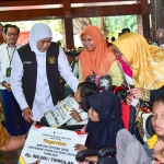 Gubernur Jawa Timur Khofifah Indar Parawansa saat penyaluran beragam bantuan sosial di Pendopo Alun-Alun Kabupaten Gresik.