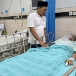 Apin Nur Zaman saat koma di RS dibesuk oleh Komisioner KPU Gresik Divisi SDM dan Parmas, Makmun, beberapa waktu lalu.
