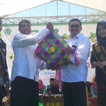 Sekretaris Disparbud menyerahkan ketupat raksasa kepada Pj Sekdakab Pamekasan falam festival ketupat raksasa di pantai Talang Siring.