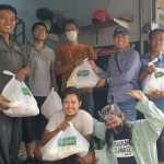 Ketua KWG, M Syuhud Almanfaluty, bersama pengurus dan anggota memberikan paket sembako. Foto: ROHMAN/BANGSAONLINE