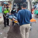 Petugas dari Polsek Prajurit Kulon saat mengevakuasi korban kecelakaan di Jalan Tribuana Tungga Dewi, Kota Mojoketo.