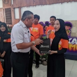 VP PT KAI Daop 7 Madiun, Suharjono, saat memberikan cenderamata kepada anak disabilitas. Foto: HENDRO SUHARTONO/ BANGSAONLINE