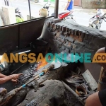 Margiono saat mambakar dan menempa besi yang dibantu anaknya. Foto: MUJI HARJITA/BANGSAONLINE