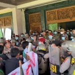 Massa aksi terlibat saling dorong dengan aparat saat berupaya masuk ke Gedung Pemkab Bangkalan lantaran tak ditemui bupati. Foto: KABARMADURA/AINUR ROFIK